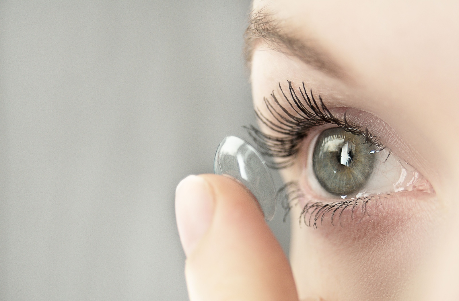 Woman putting in daily contact lenses.