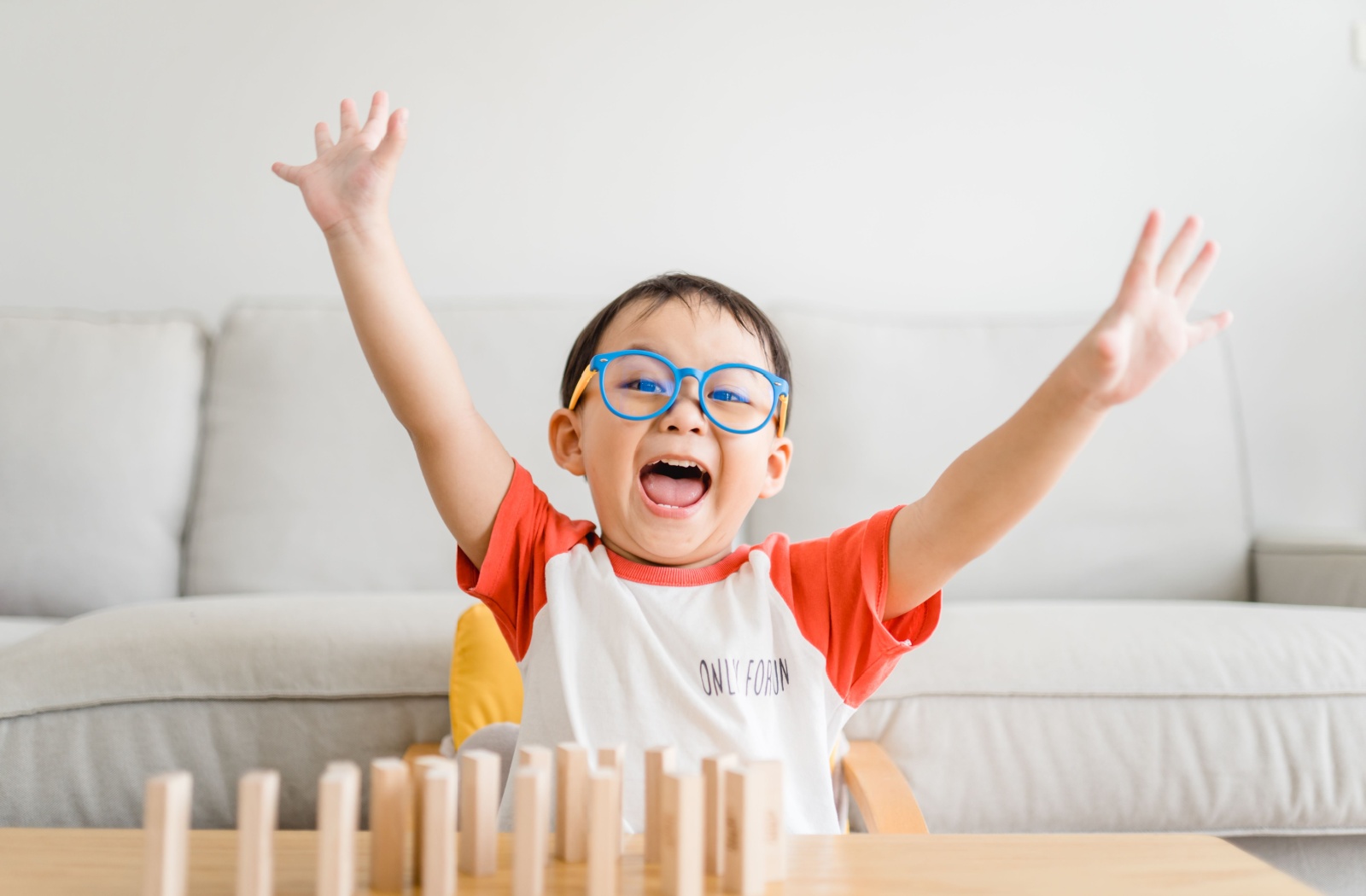 A happy, young child wearing specialized myopia-control eyeglasses.